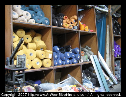 Bins full of large spools of brightly colored wool yarn.