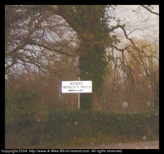 Sign pointing to Kerry Woolen Mills with rain drops on lens