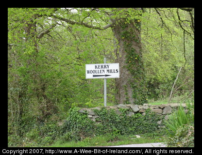 Sign pointing to Kerry Woolen Mills in May with green grass and sunshine instead of dark and brown.