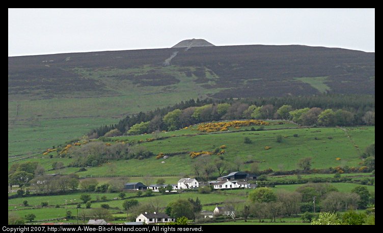 A mountain with a mound of stones on top.