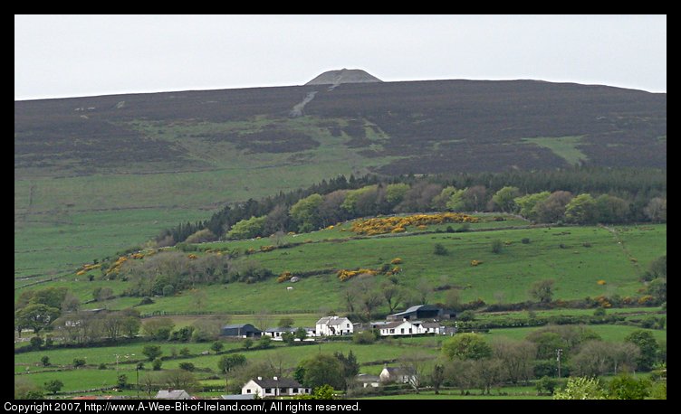 A mountain with a mound of stones on top.