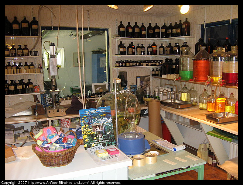 Equipment for making perfume and shelves full of bottles and jugs.