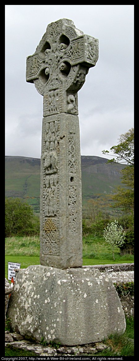 A celtic high cross carved from sandstone with celtic knots and images from the Bible. It is over 12 feet tall including the pedestal that it rests upon.