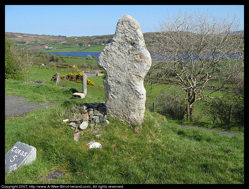 A cross carve from stone about 1400 years ago and now weathered with Gartan Lough (lake) in the background.