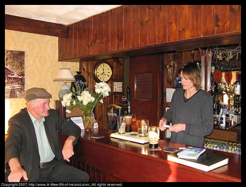 A man wearing an Irish cap and a woman tending bar.