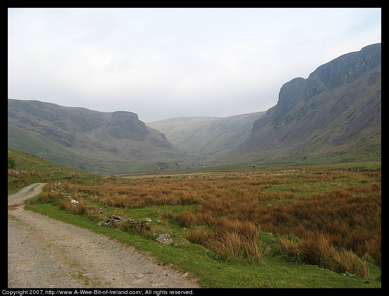 A winding road through the valley above Lough Anscaul with steep mountains on either side.