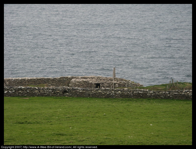 Ancient stone fort surrounded by stone walls and green grass