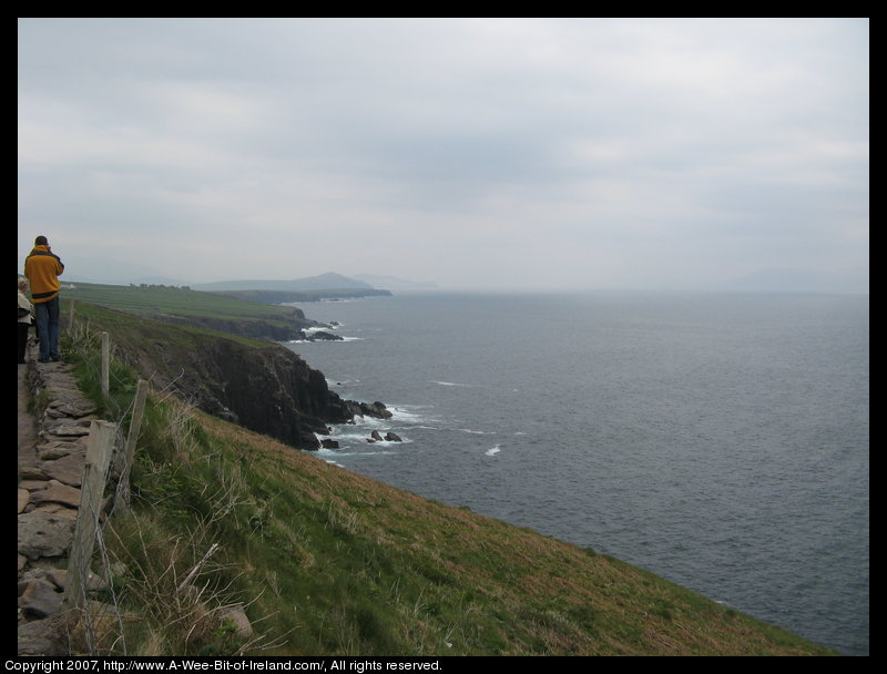 Slea Head Scenic Drive, cliffs falling to the ocean with waves crashing against the cliffs and sending up spray.