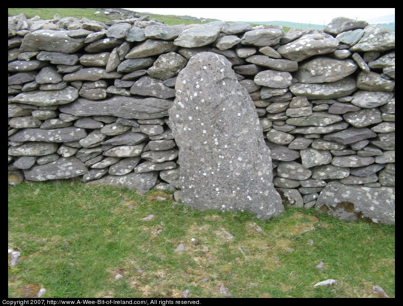 Slab of stone next to a stone wall.