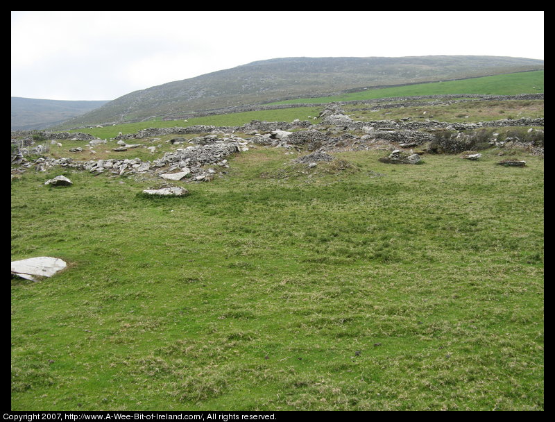 Stone walls and piles of stones and large stone slabs.