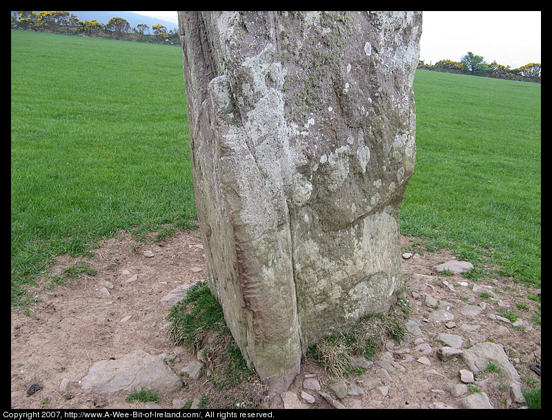 standing stone with slashes on the corner of the stone that are writing in an ancient alphabet.