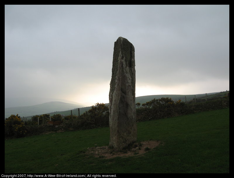 standing stone with slashes on the corner of the stone that are writing in an ancient alphabet.