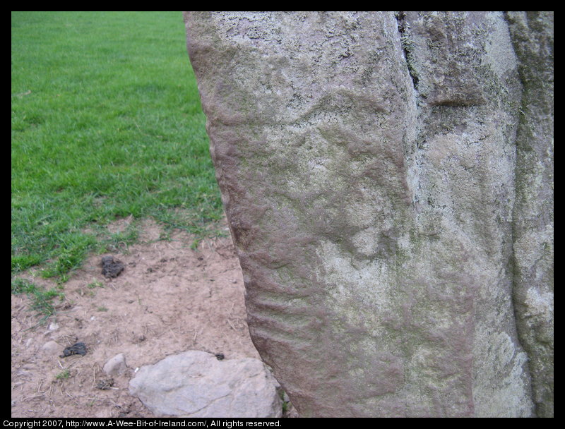 standing stone with slashes on the corner of the stone that are writing in an ancient alphabet.