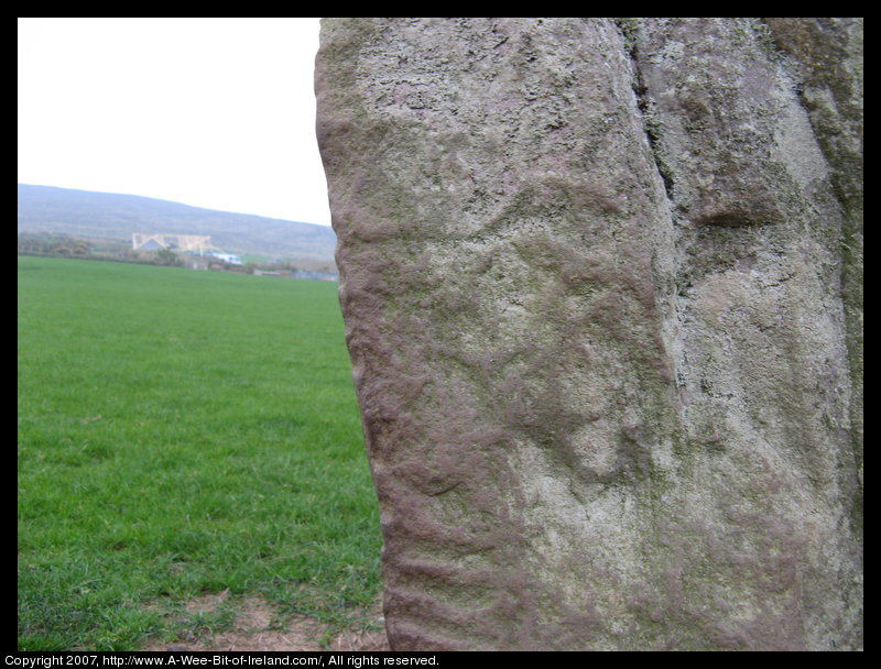 standing stone with slashes on the corner of the stone that are writing in an ancient alphabet.