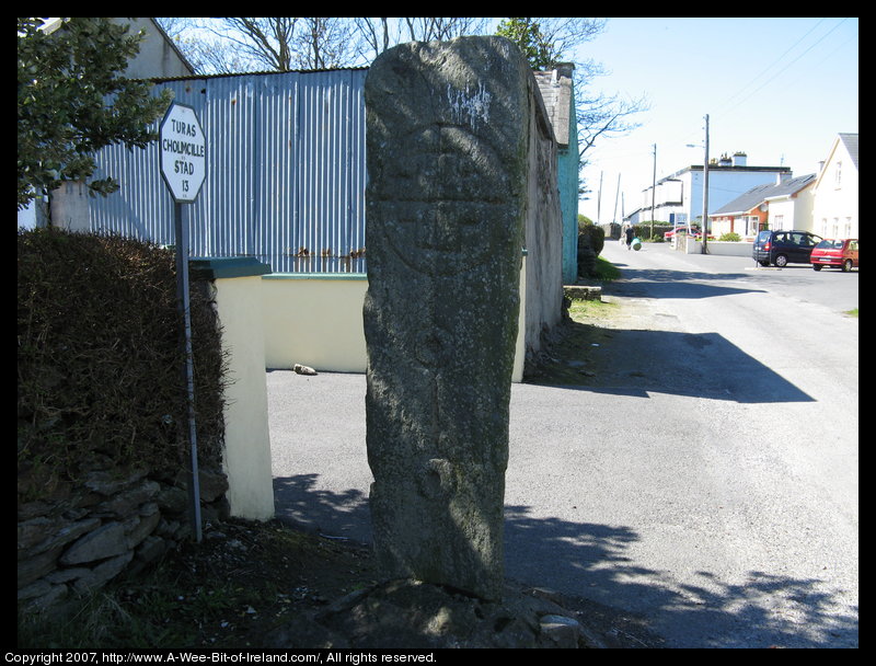 standing stone with a cross inscibed on it. The cross slab is on a street corner in Glencolumcille, Donegal.