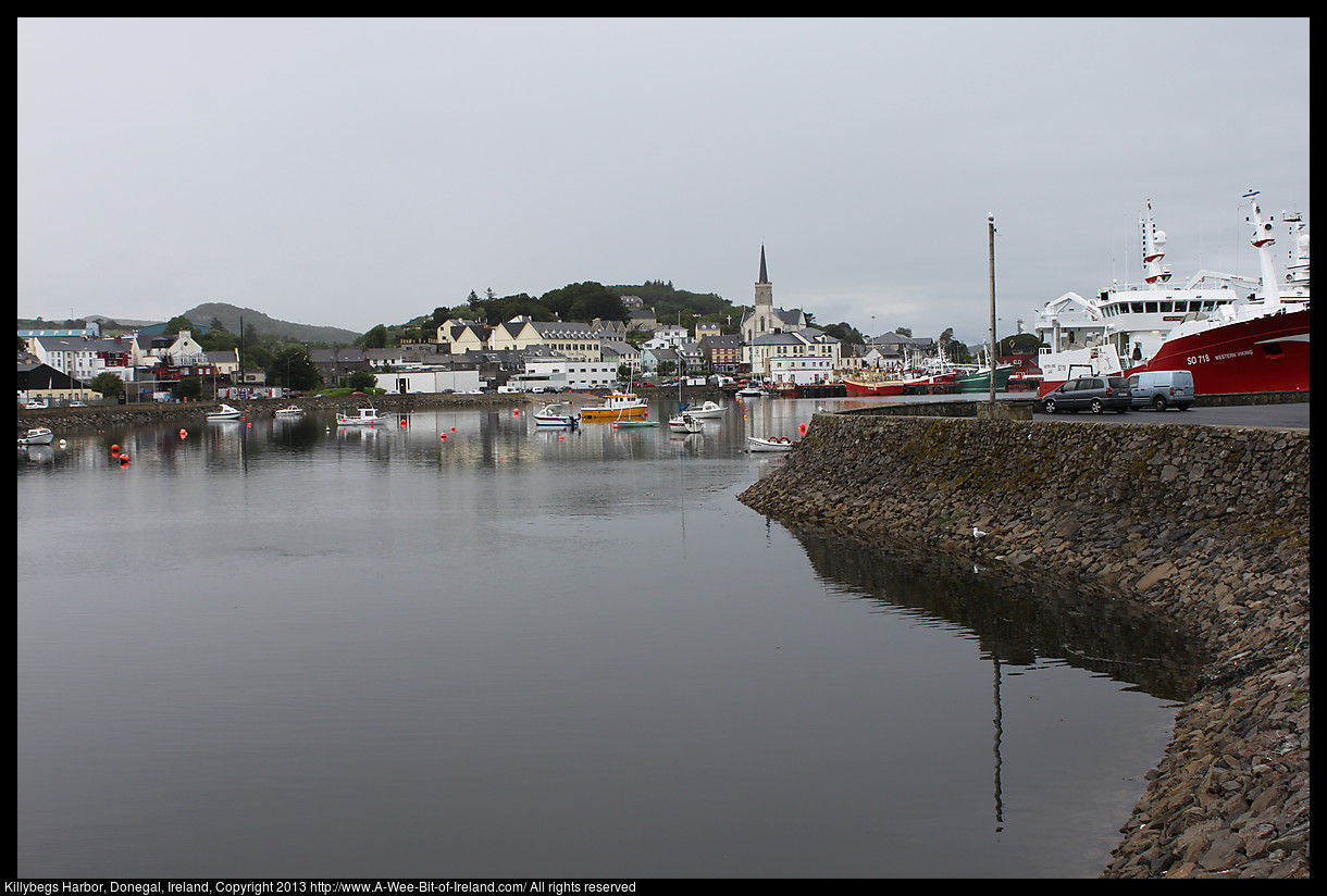 A harbor with various sizes of boats and ships and buildings along the shore.