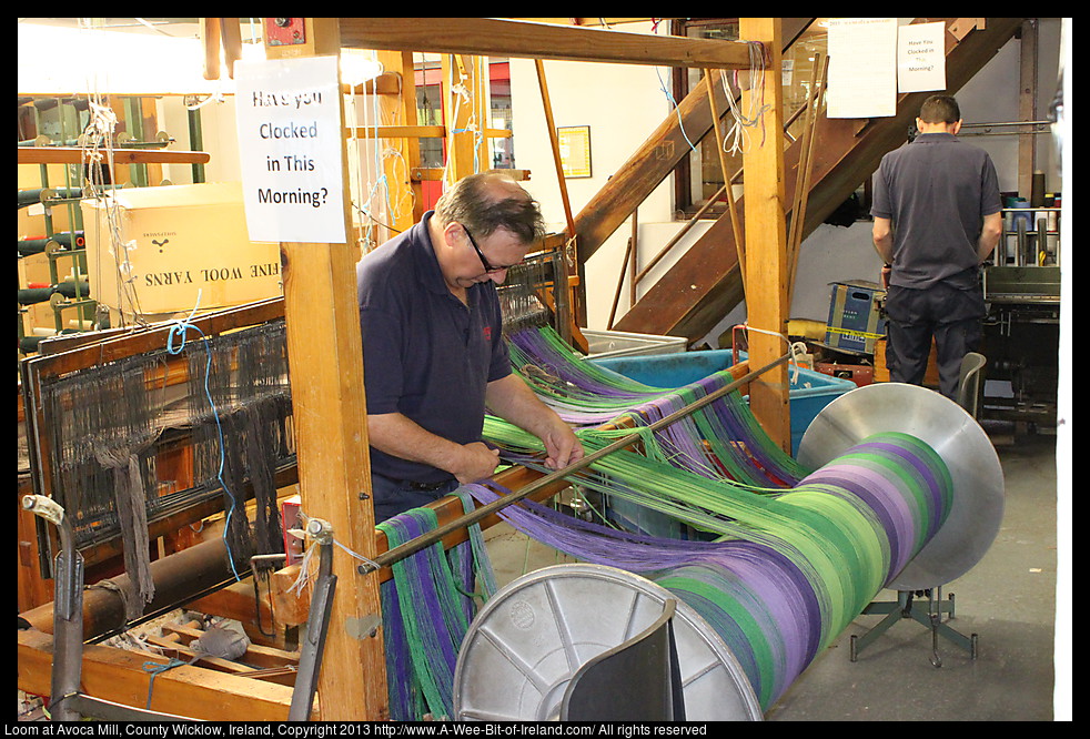 A man is working with yarn in preparation for weaving cloth.