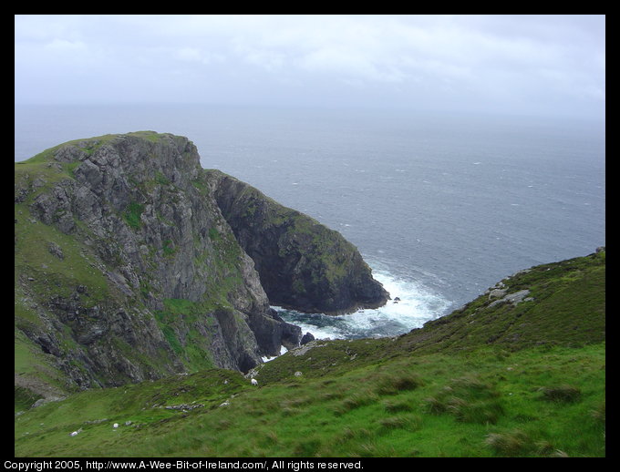 Carrigan Hill. Cliffs with Atlantic Ocean waves crashing against them.