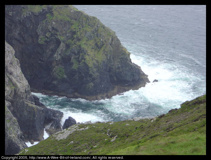 Carrigan Hill. Cliffs with Atlantic Ocean waves crashing against them.