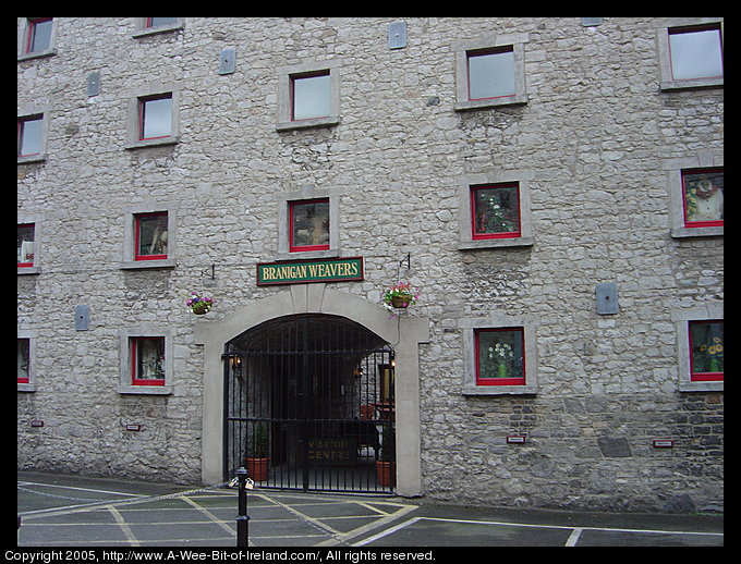 A 300 year old factory made of gray stone with bright red trim.