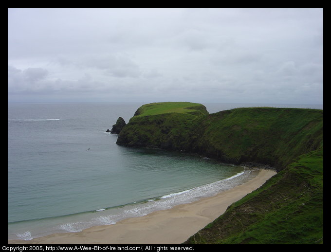 A sandy beach near rocky cliffs.