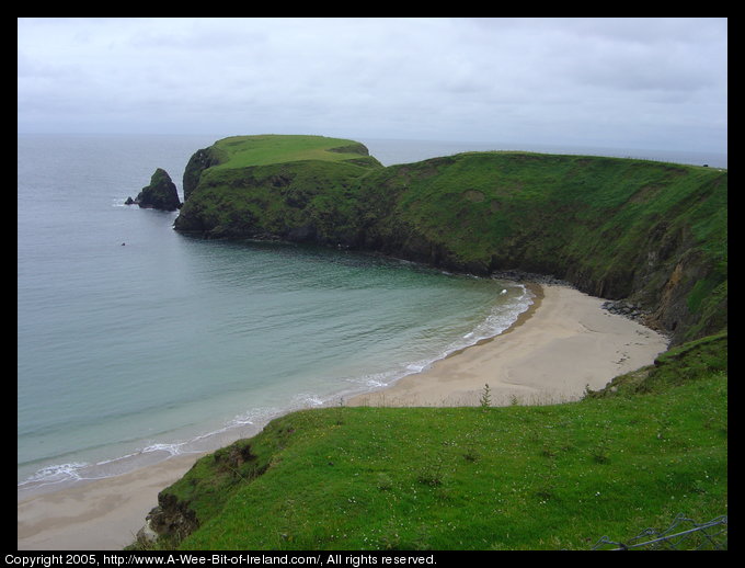 A sandy beach near rocky cliffs.