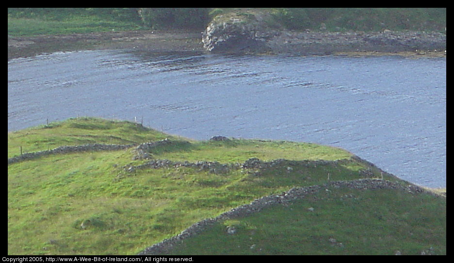 A ring fort on a hill next to stone fences and Tawny Bay near Kilcar,
 Donegal.