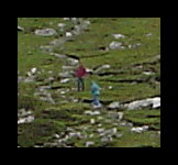 Two tourists are climbing toward the top of Slieve League.