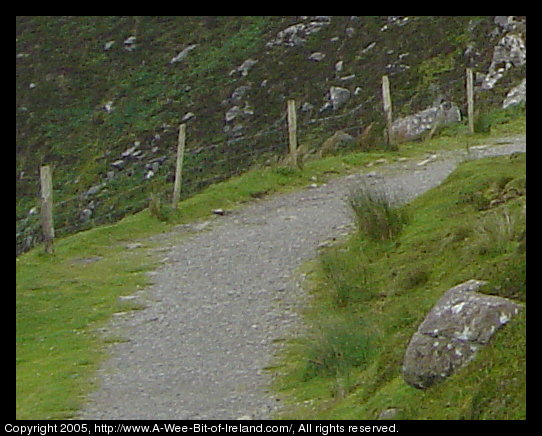 Path near Slieve League sea cliffs with a fence on the left. The fence is woven wire and is right at the edge of the cliff.