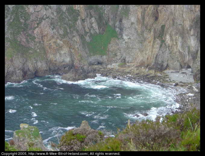 Slieve League sea cliffs, looking almost straight down to waves crashing on rocks.